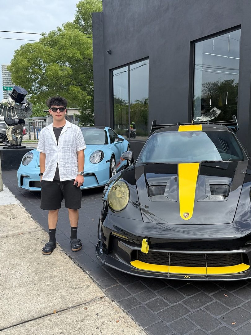 Seyhaun Bozorgi standing beside a Porsche 911 GT3 RS in Miami